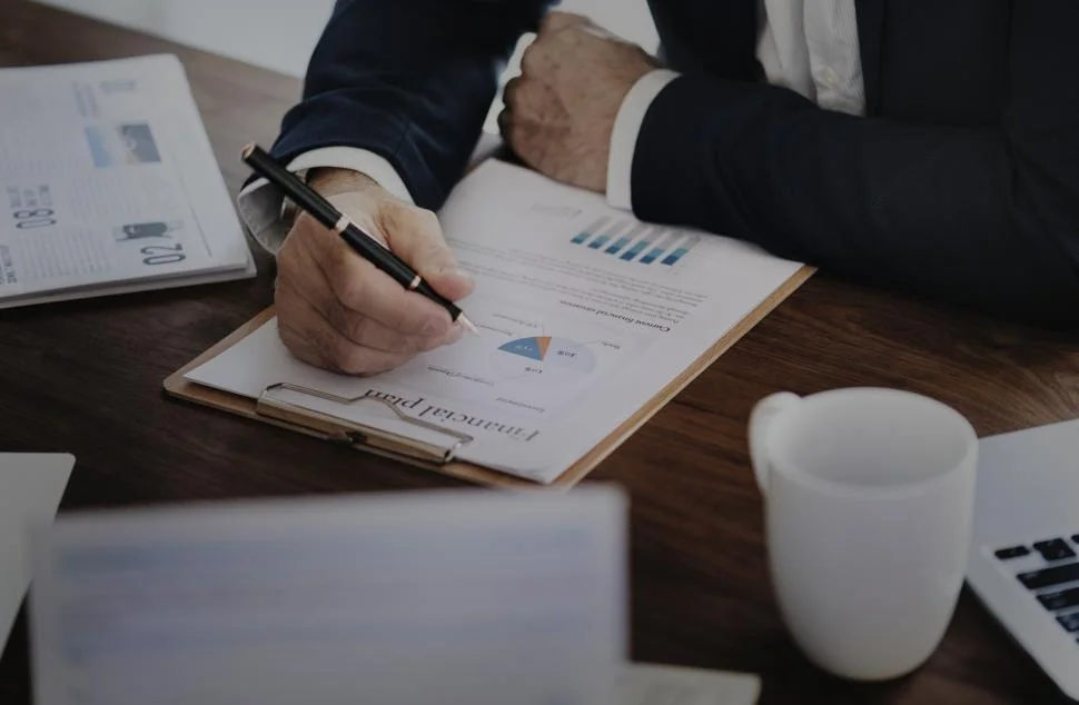 close up of a person s hand with a pen checking financial plan